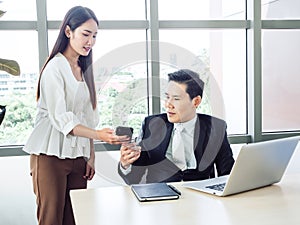Asian businessman, boss working with young woman secretary on desk in office