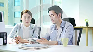 Asian businessman and businesswoman working together in office