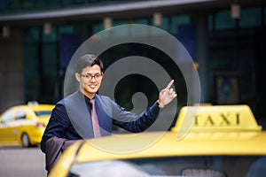 Asian businessman calling taxi car leaving work