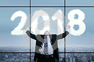 Asian businessman with clouds shaped numbers 2018