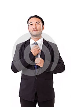 Asian businessman fastening his necktie