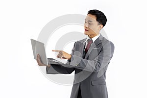 Asian businessman in grey suit white shirt red tie toching and pointing on notbook screen white background