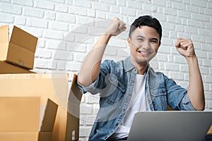 Asian businessman happy with success He clenched his fists in a winning gesture. online shopping business at home