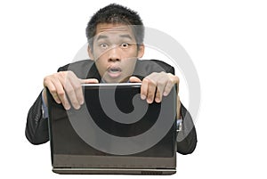 Asian businessman hiding behind laptop