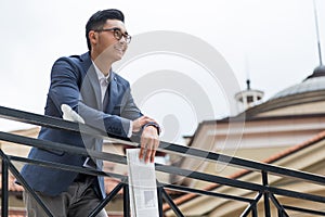 Asian businessman holding newspaper