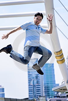 Asian businessman jumping with building and cityscape background