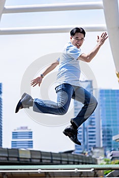 Asian businessman jumping with building and cityscape background