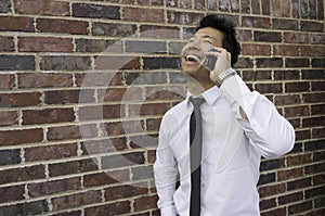 Asian Businessman Laughing and talking on the mobile phone