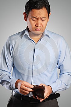 Asian Businessman Looking Sad with Empty Wallet