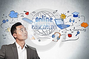 Asian businessman looks at online education icons