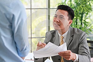 Asian businessman manager in suit holding paperwork and strong talking for young employee with anger and serious gesture look like