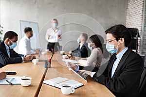 Asian Businessman In Mask Using Tablet During Corporate Meeting Indoor