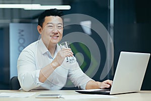 Asian businessman in the office drinking clean filtered water