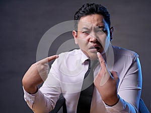 Asian Businessman Pointing Himself with Unhappy Expression as if he confused to be accused