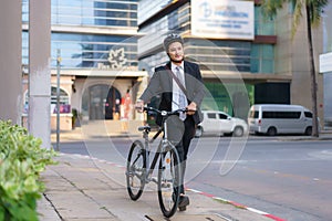 Asian businessman pushing his bicycle from home in the morning preparing to ride his bicycle to work. Eco tranportation