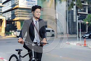 Asian businessman pushing his bicycle from home in the morning preparing to ride his bicycle to work. Eco tranportation