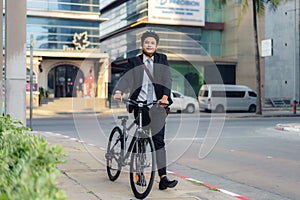 Asian businessman pushing his bicycle from home in the morning preparing to ride his bicycle to work. Eco tranportation