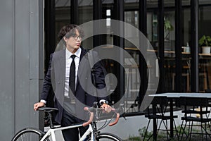 Asian businessman pushing his bicycle in the morning preparing to ride his bicycle to work. Eco tranportation