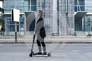 Asian businessman riding an electric scooter on the city streets to go to work in the morning. Daily commute that best reflect the