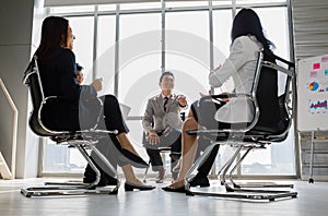 Asian businessman sitting and speaking as chairman of company meeting