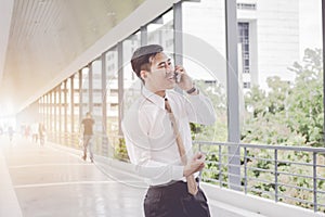 Asian Businessman are smiling call phone talking and relax, Meetings between executives. between waiting on On sidewalks.