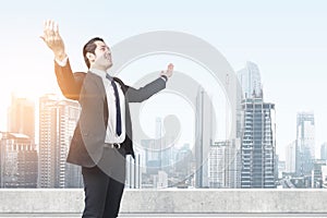 Asian businessman standing with raised hand on the rooftop