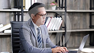 Asian businessman struggle with laptop computer, Frustrated asia man looking at computer while working at office, Business people