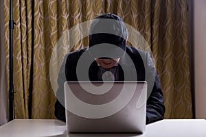 Asian businessman in suit attempting to hack computer network