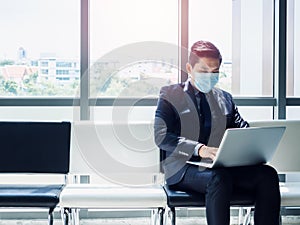 Asian businessman in suit wearing protective face mask.