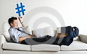 Asian businessman taking break laying on couch