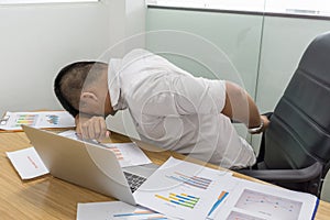 Asian businessman touching aching back with pained expression