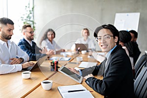 Asian Businessman Using Digital Tablet Attending Corporate Meeting In Office