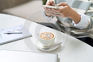 Asian businessman using mobile phone during coffee break on tab