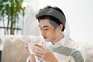 Asian businessman using mobile phone during coffee break on tab