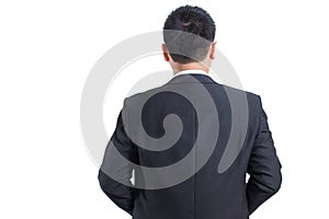 Asian businessman wear black suit Stand up to the back with crossed arms and look at the left hand side.