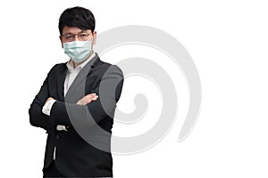 Asian businessman wearing surgical face mask in formal black suit jacket, crossing the arms, studio lighting