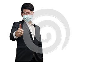 Asian businessman wearing surgical face mask in formal black suit jacket, show trumps up by right hand and look at the camera photo