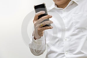 Asian businessman wearing white shirt holding a smart mobile phone on white background with copy space