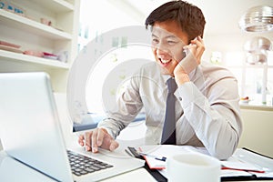 Asian Businessman Working From Home Using Mobile Phone