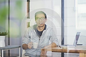 Asian businessman working on laptop in office alone