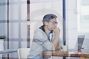 Asian businessman working on laptop in office alone