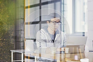 Asian businessman working on laptop in office alone