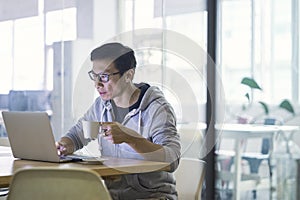 Asian businessman working on laptop in office alone