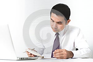 Asian businessman working seriously in the office with laptop co