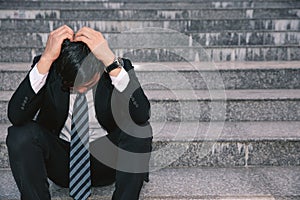 Asian businessmen with headaches or migraines at the city hall after work Images of young businessmen who are tired, stress, crisi