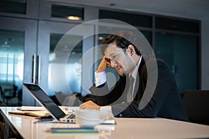 Asian businessmen using notebook for working and businessman serious about the work done until the headache