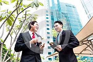 Asian businesspeople drinking coffee outside