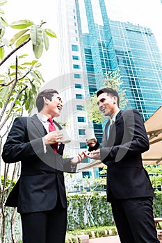 Asian businesspeople drinking coffee outside