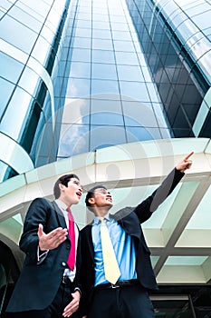 Asian businesspeople in front of high rise building