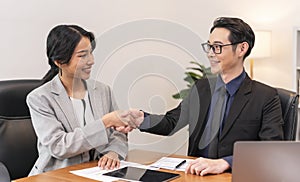 Asian businesspeople shake hands starting collaboration at negotiations, positive businesspeople gathered at office boardroom,